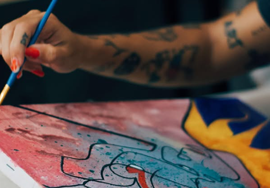 Mãos pintando em canvas — transição entre arte e ciência